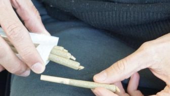 Man holding pre Roll tubes in his hand.