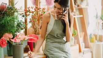 A woman taking orders in a flower shop.