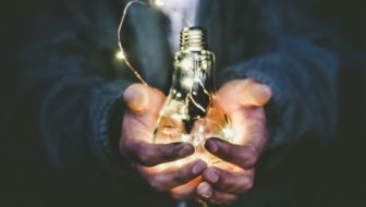 A man holding a light bulb in his palms.