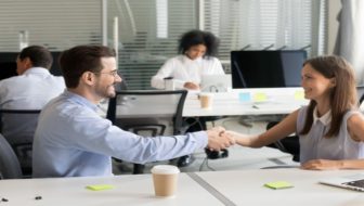 A man and woman shaking their hands.