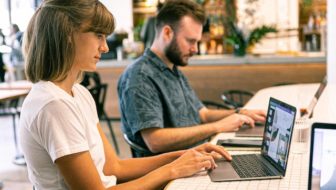 Man and woman working on their laptops.