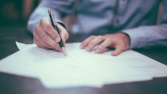 A man signing Life Insurance papers.