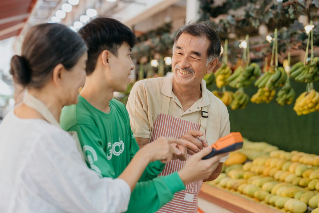 A couple at a farmer’s market stand with the owner