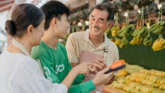 A couple at a farmer’s market stand with the owner